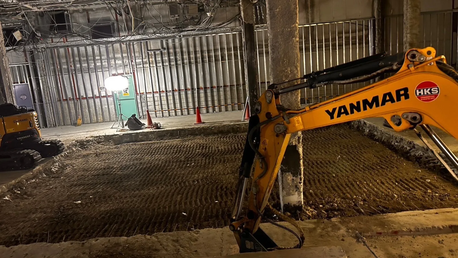 屋内の解体現場で稼働する重機